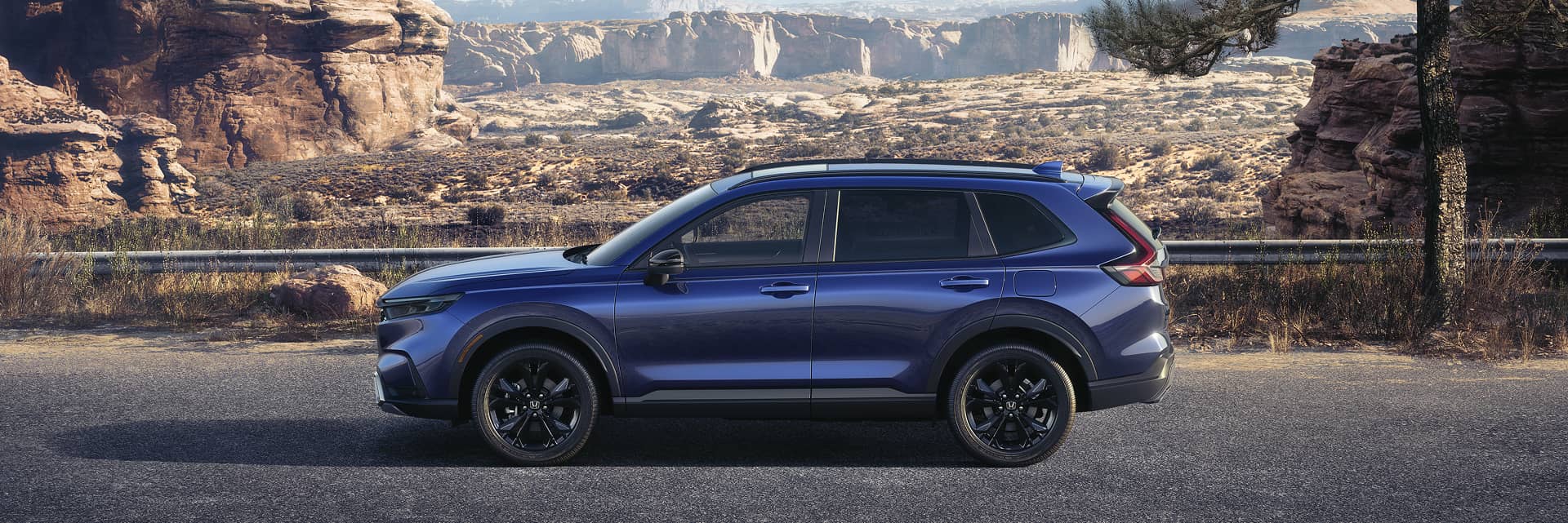 A blue honda cr-v parked in front of mountains