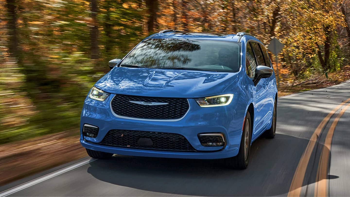 blue chrysler pacifica phev driving on road in fall