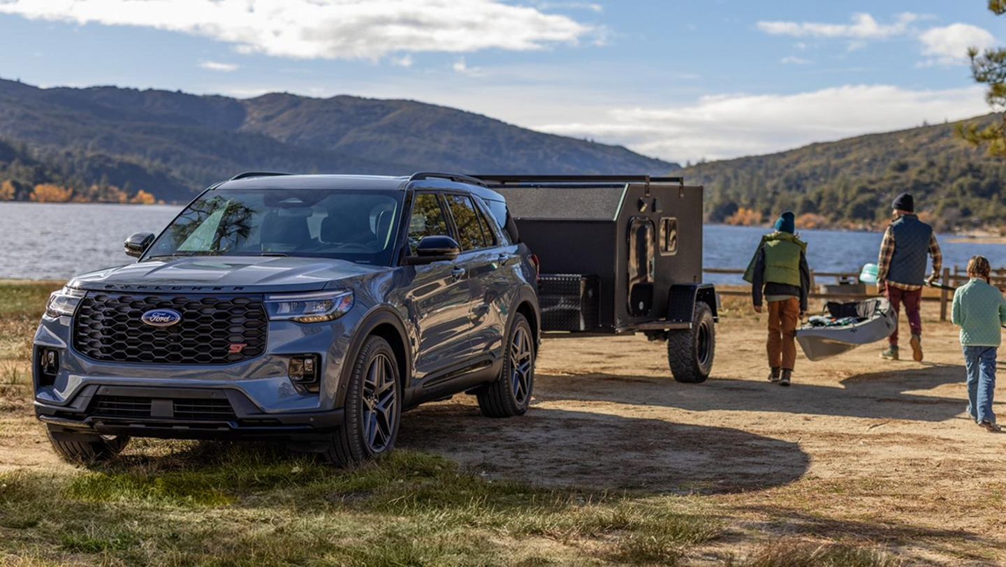 family next to ford explorer by the water