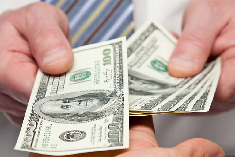 Hands Holding a Handful of 100 Bills